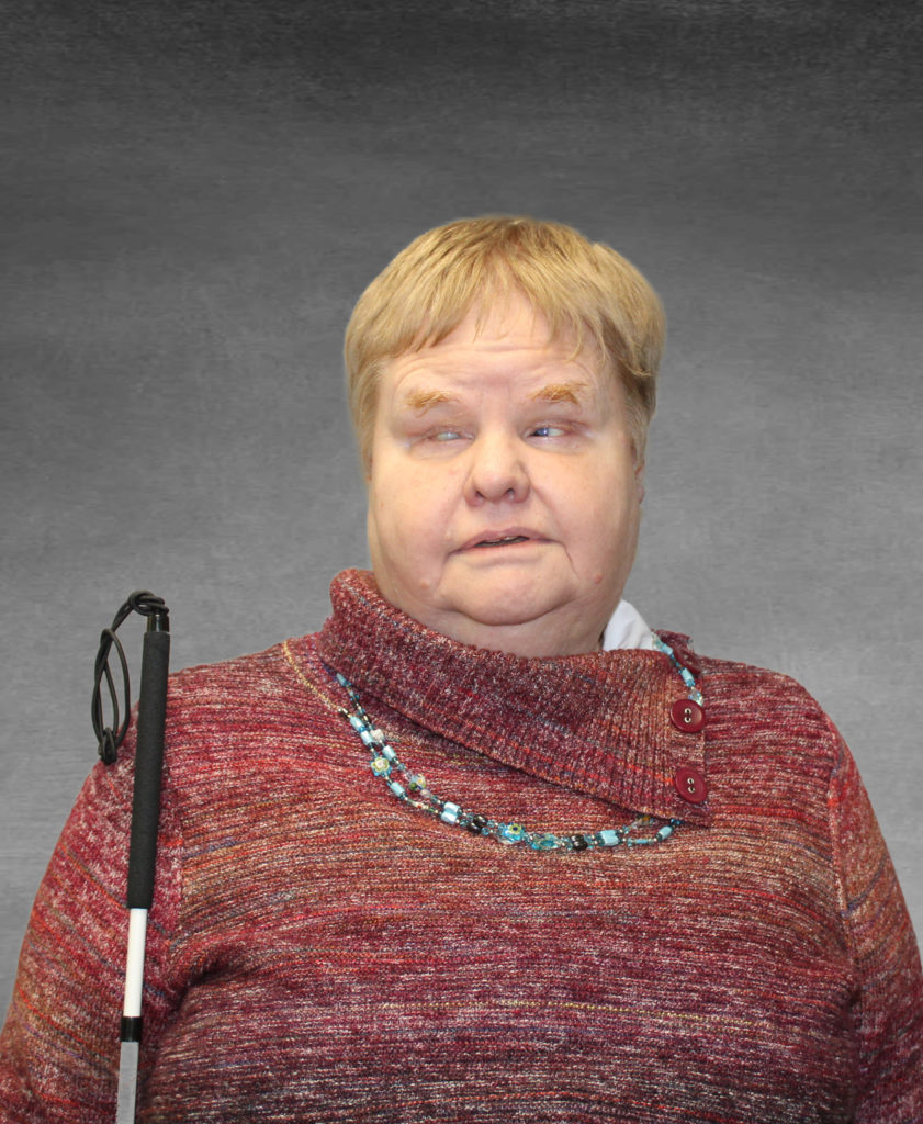 Professional headshot of Charis. She is wearing a heathered red sweater and a blue beaded necklace.