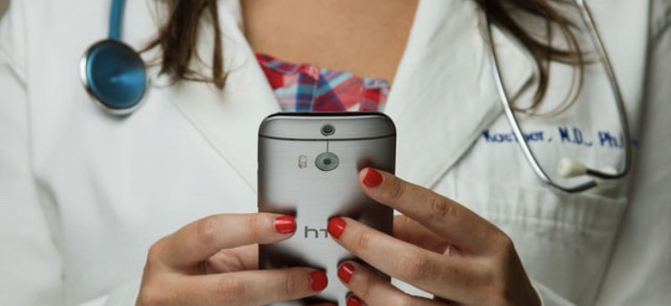 Up close photo of a female doctor holding a cell phone