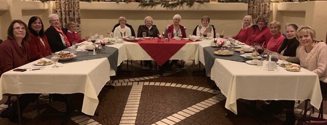 Photo of the Psi Iota Xi women sitting at tables in a u shape