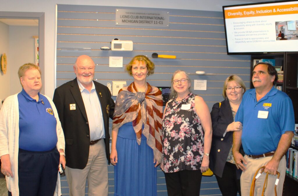 Lions Club members standing in front of the technology wall