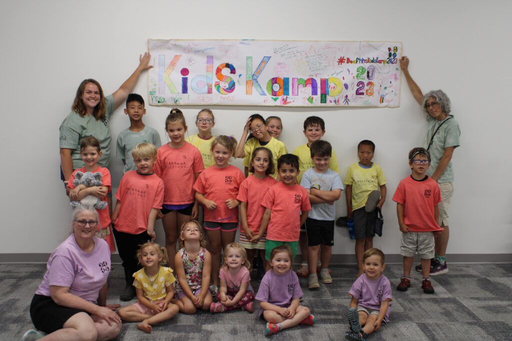 Kids Kampers standing under a banner they decorated