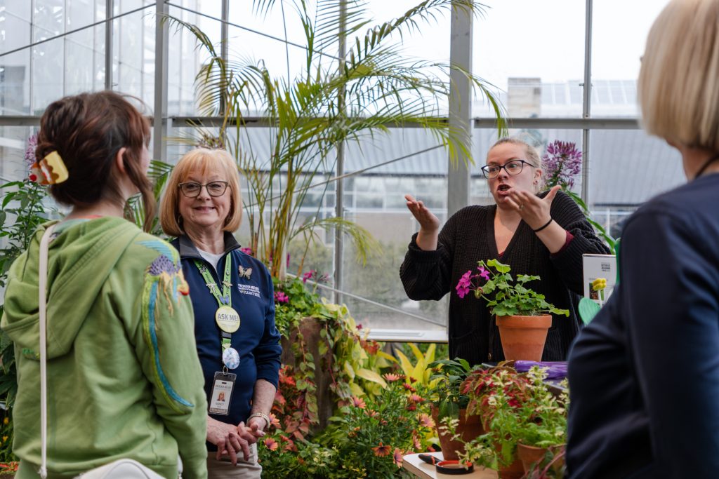 Group of attendees talking with a volunteer using a sign language interpreter